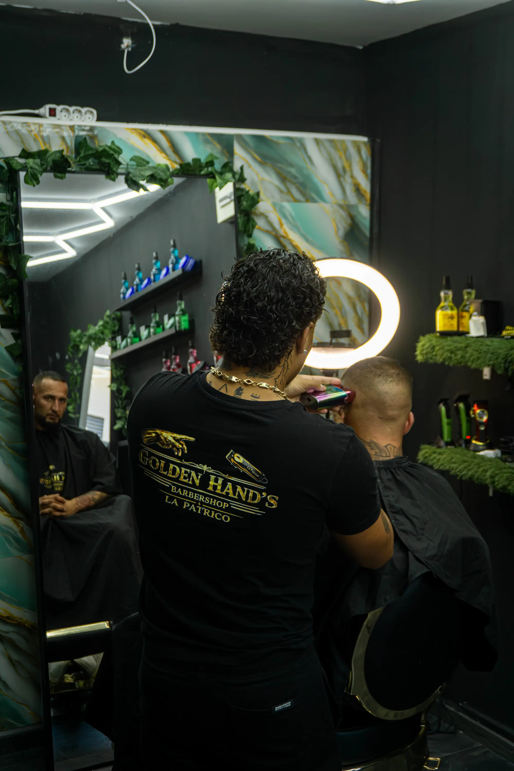 Hajvágás közben, Golden Hand's Barbershop feliratos pólóban